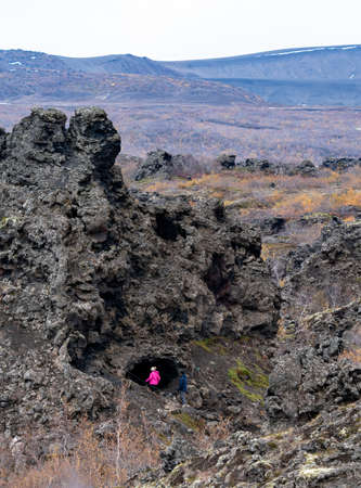 Vast lava field with unrecognizable tourists hikingの写真素材