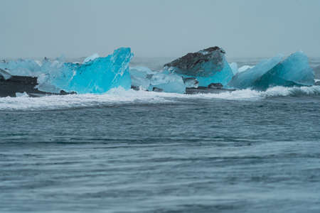 Blue icebergs over the black sand beach