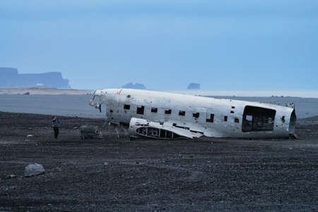 Wreck of an airplane profile and boulders with blurred touristの写真素材