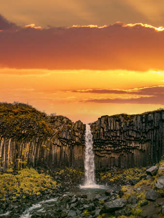 Svartifoss waterfall in Skaftafell National Park under orange skyの写真素材