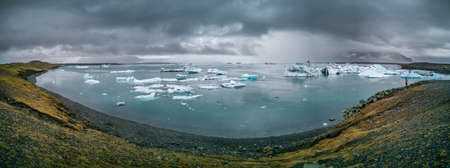 Spectacular panorama in Jokulsarlon with unrecognizable touristの写真素材