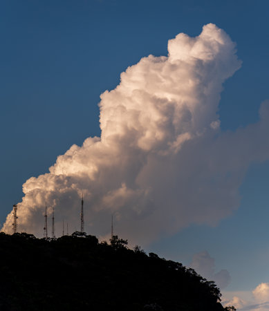 Majestic mountain silhouette under a towering cloudの写真素材