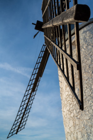Bottom view of vintage windmill blades against blue skyの写真素材