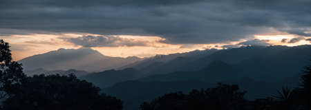 Majestic Mountain Range with Layers of Colors at Sunsetの写真素材