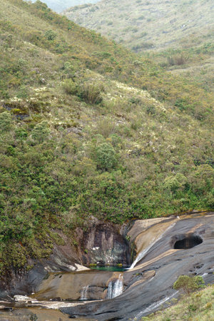Colorful rock pools and bushy mountain slopes in Caparaos enchanted valleyの写真素材