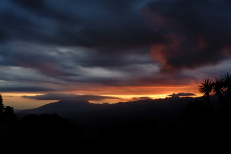 Moody long exposure of stormy dusk sky over mountainsの写真素材