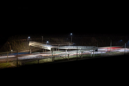 Pedestrian Bridge over Highway with Light Trails and Space for Text .の写真素材