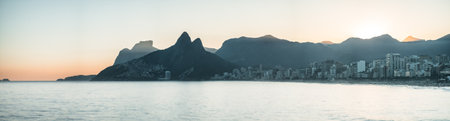 Mystic Sunset Over Ipanema Beach with Favelas and Mountain Silhouettesの写真素材