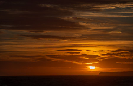 Majestic Lighthouse Overlooking Sunset and Infinite Seaの写真素材