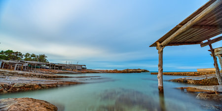 Long Exposure of Old Dock with Rails Leading to Clear Seaの写真素材