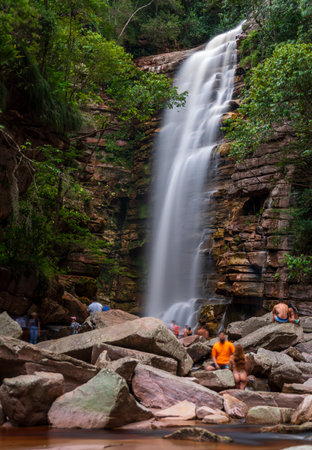 Majestic Waterfall in Lush Forest With Observing Visitorsの写真素材