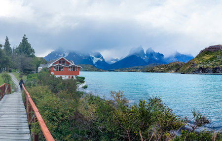 Red House by the Turquoise Lake in Mountainous Landscapeの写真素材
