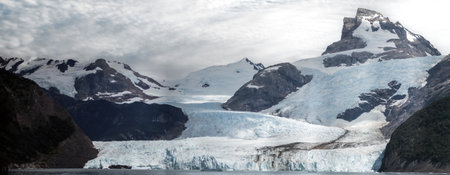 Majestic Glacier View with Snowy Peaks and Cloudy Skyの写真素材