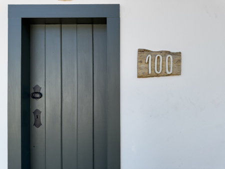 Classic Wooden Door Number 100 on a White Wallの写真素材
