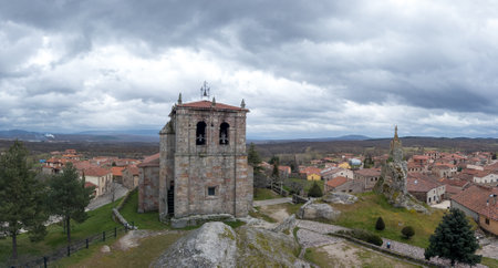 Charming Village with Ancient Stone Tower and Cloudsの写真素材