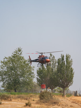 Helicopter Fighting Forest Fire with Water Bucket