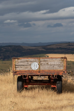 Vintage Wooden Farm Trailer in Countryside Landscapeの写真素材