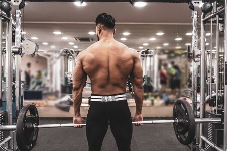 Muscular Man Doing Heavy Deadlift Exercise. Young athlete getting ready for weight lifting trainingの写真素材