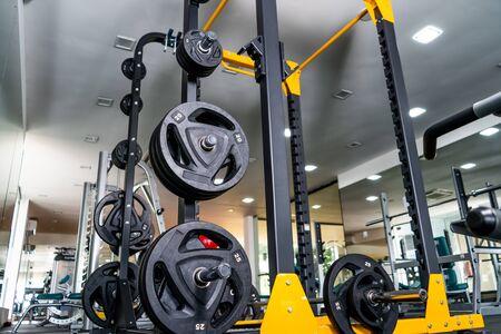 Modern light gym. Sports equipment in gym. Barbells of different weight on rack.の写真素材