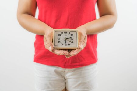 closeup on alarm clock in hands of women period dayの写真素材