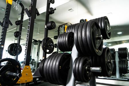 Modern light gym. Sports equipment in gym. Barbells of different weight on rack.の写真素材