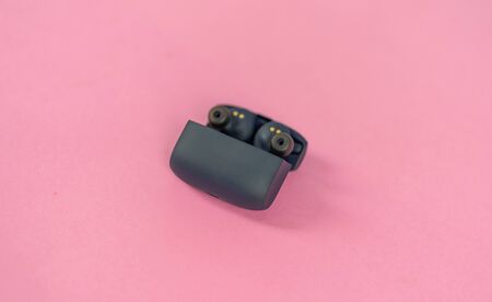 Wireless headphones on pink table with backgroundの写真素材