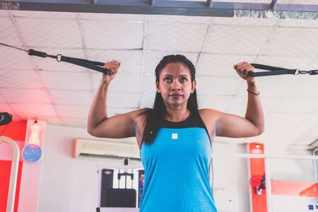 Young woman weight training at gym
