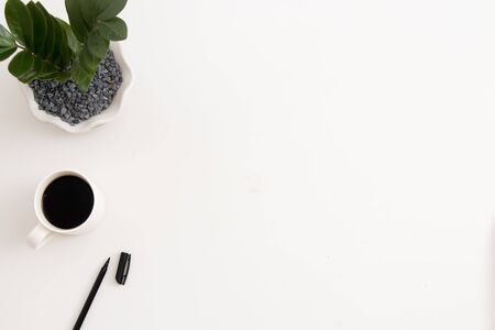White office desk with office plant, coffee and pen. Top view with copy space, flat layの写真素材