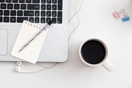 White office desk with notebook and pen coffee. Top view with copy space, flat layの写真素材