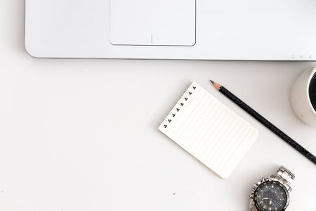 White office desk with laptop, notebook pen and hand watch. Top view with copy space, flat layの写真素材