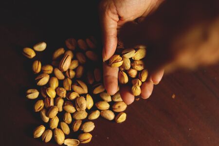 Dried pistachio nuts in class with brown backgroundの写真素材