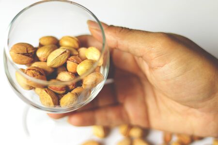 Dried pistachio nuts in class with white backgroundの写真素材