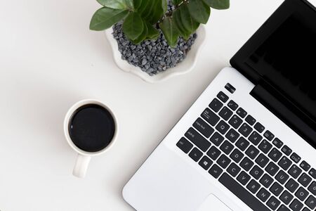 White office desk with laptop, office plant and coffee. Top view with copy space, flat layの写真素材