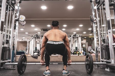 Muscular Man Doing Heavy Deadlift Exercise. Young athlete getting ready for weight lifting trainingの写真素材