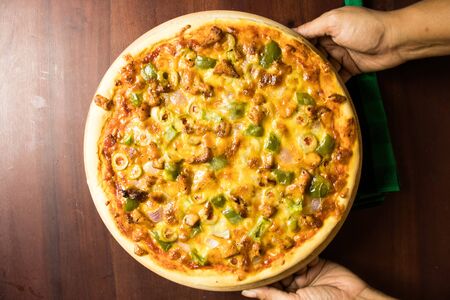 Pan Pizza take from top closeup hold handsの写真素材