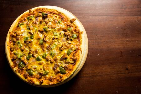 Pan Pizza take from top left side with space on dark brown woodの写真素材