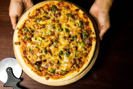 Pan Pizza take from top closeup hold handsの写真素材
