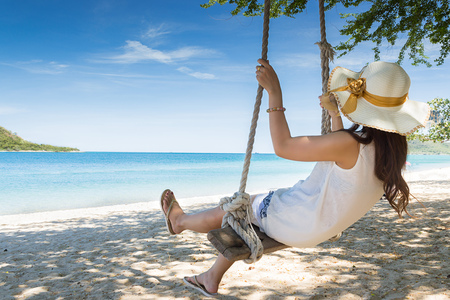 Girl on swing at the beach in Thailandの写真素材
