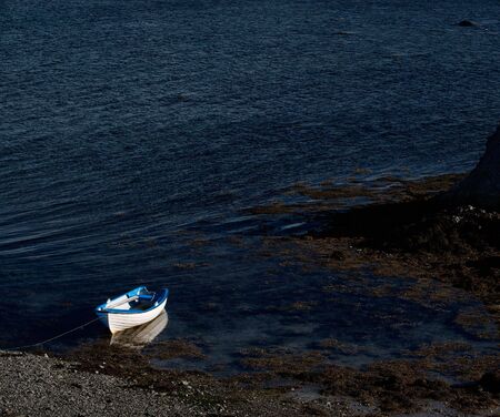 Blue and white  boat in small bay, Northern Norwayの写真素材