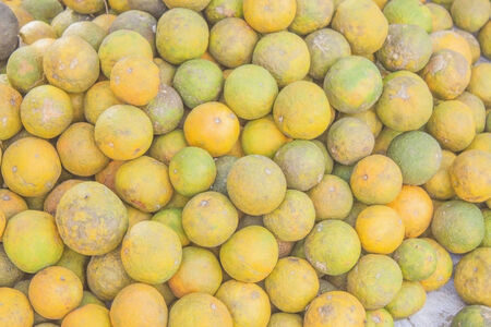 Vietnamese green and yellow oranges, at a market