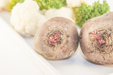 A few beetroots, in front of cauliflower and broccoliの写真素材