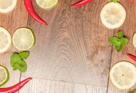 Chili, lime, mint and lemon background, on wooden backgroundの写真素材