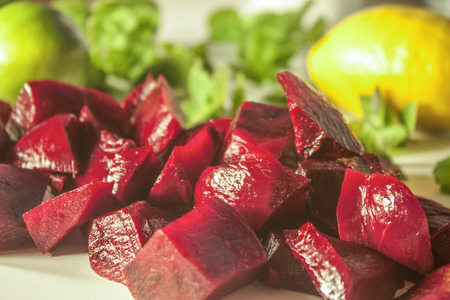 Lilac beetroot diced on a white table, near lemon and mint