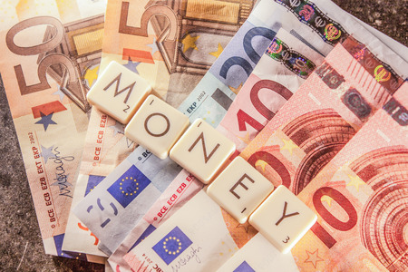 Money text on a bunch of euro billsの写真素材