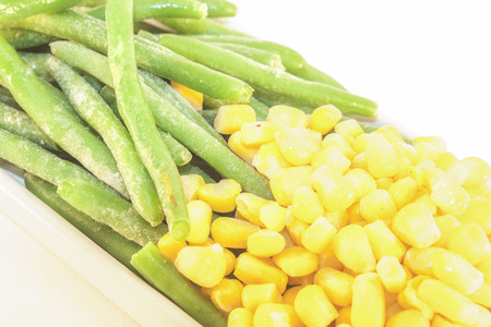 Green beans and yellow corn, isolated on white backgroundの写真素材