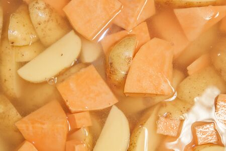 Potato and sweet potato cubes, boiling in water