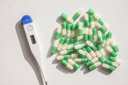 Blue - white thermometer and green - white pillsの写真素材