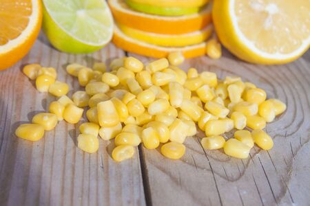 Sweet corn in front of lime, lemon and orangeの写真素材