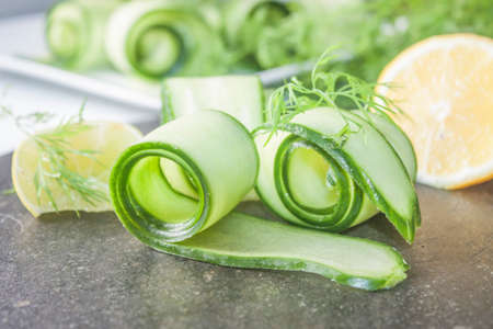 Two cucumber rolls, near lime, lemon and dillの写真素材