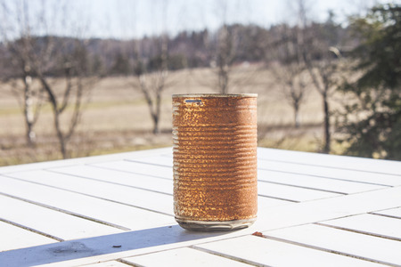Lonely rusty can, on a white tableの写真素材